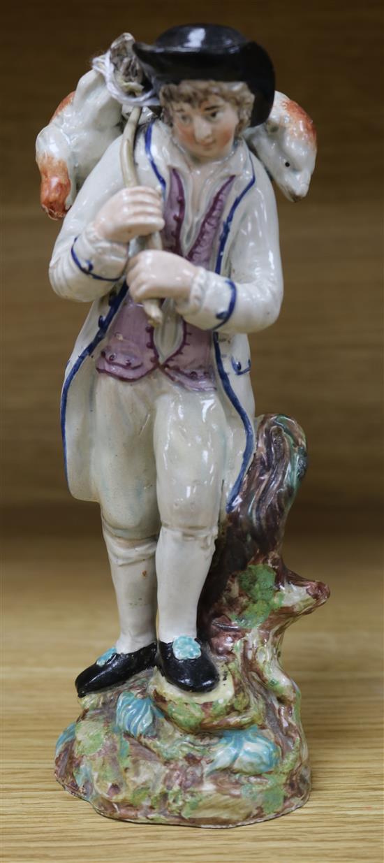 An early Staffordshire Walton-type figure of a shepherd carrying a lamb, on naturalistic base, H 7.5in
